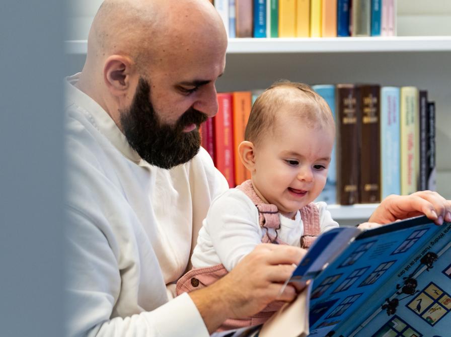 Mand sidder med lille barn